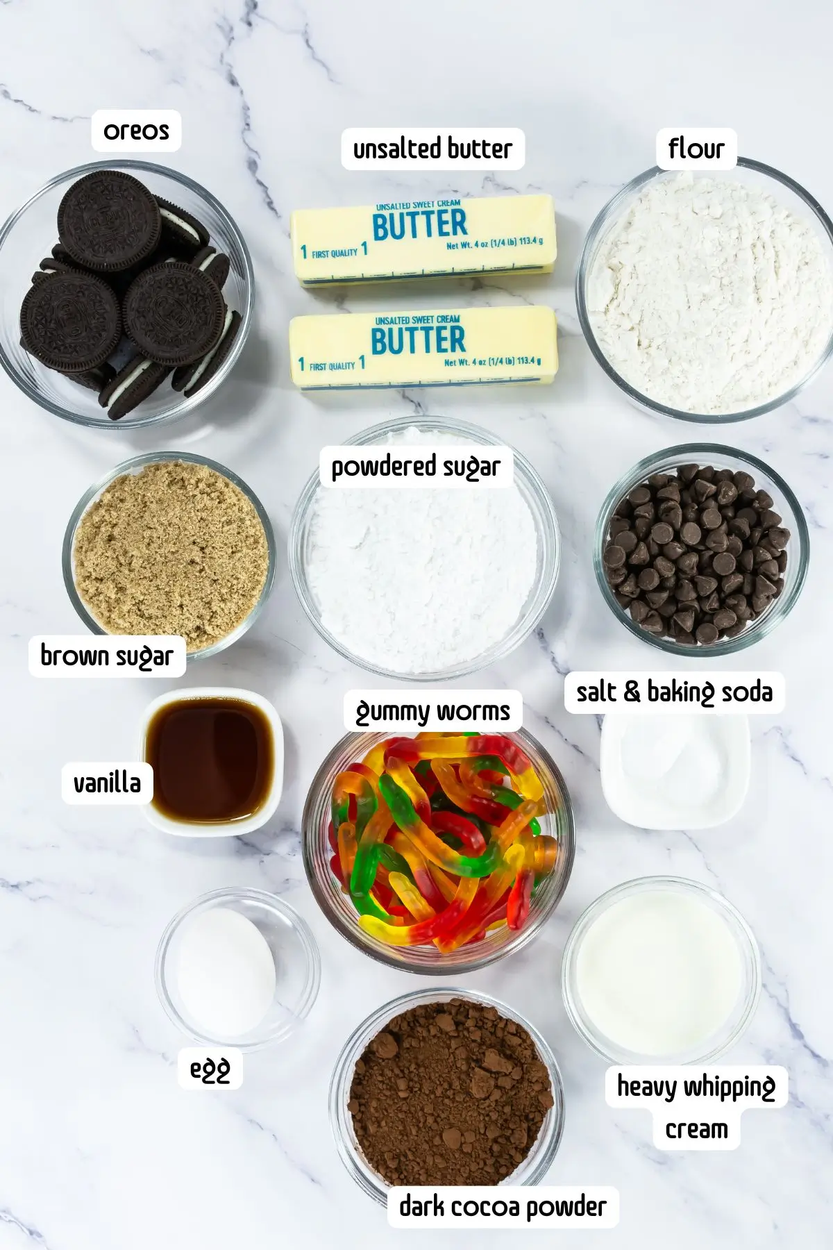 Flat lay of Oreo dirt cookie ingredients with gummy worms and cocoa