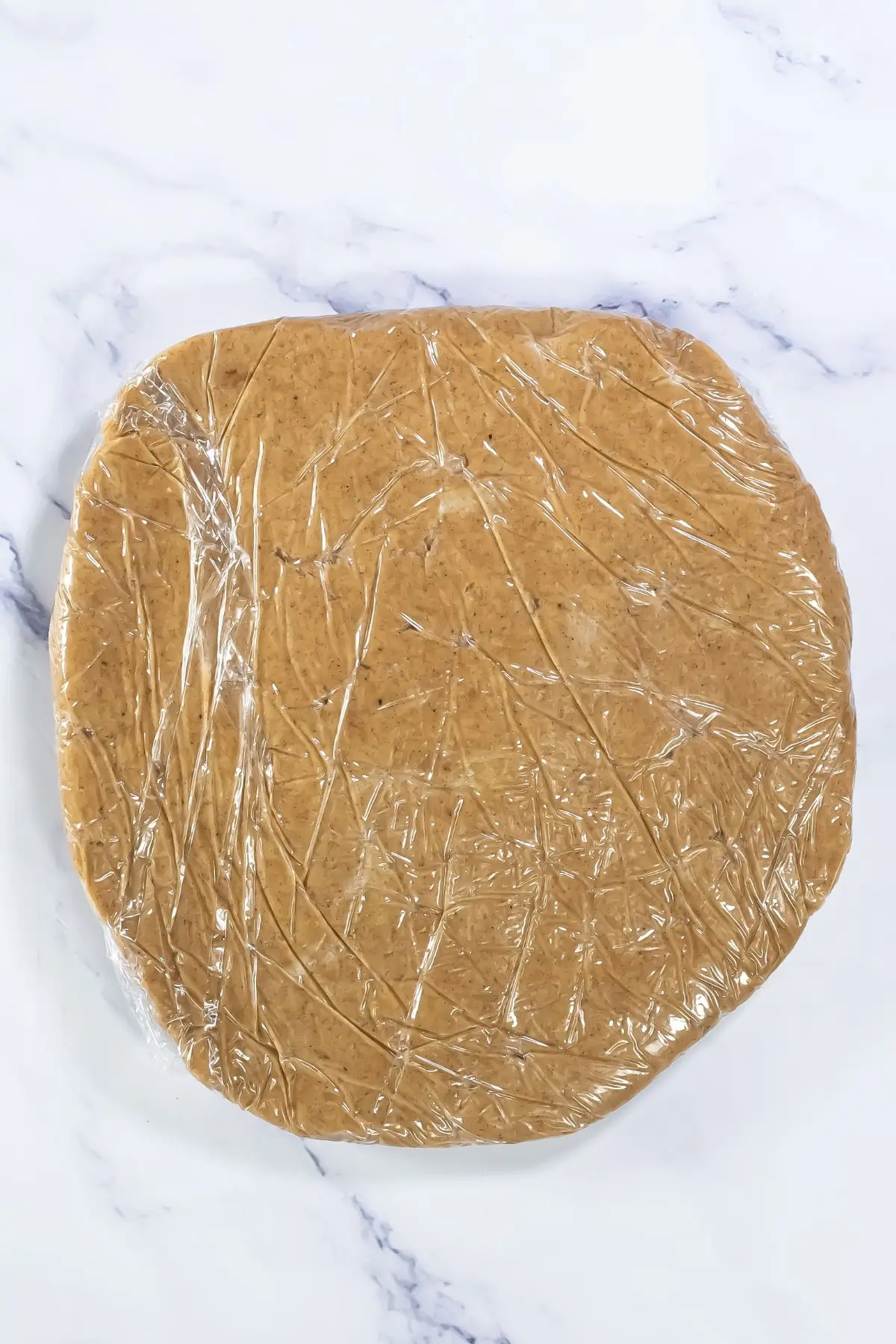 The Bestest Pumpkin Linzer Cookies Flattened cookie dough disc wrapped in plastic, ready to chill