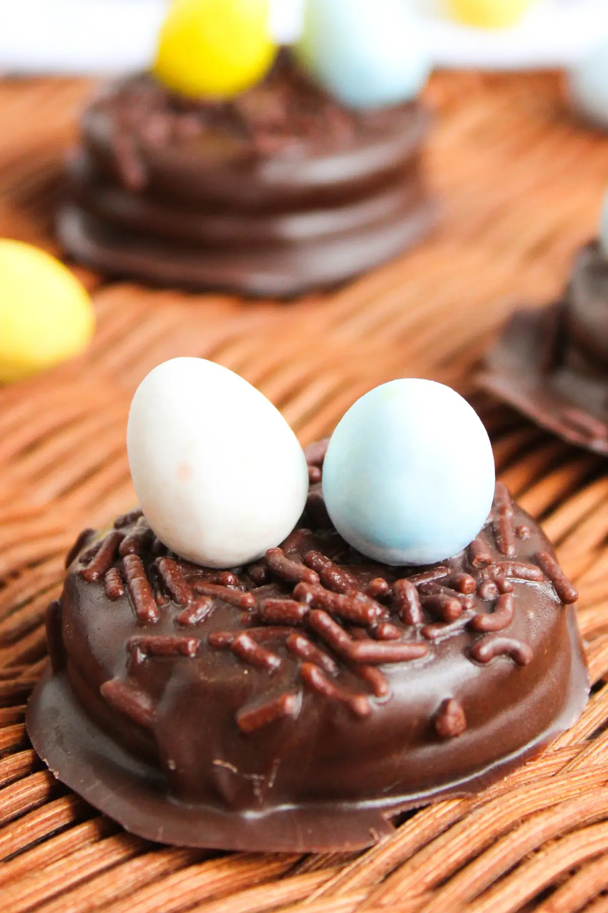 Chocolate-covered cookie nest topped with chocolate sprinkles and pastel candy eggs for Easter