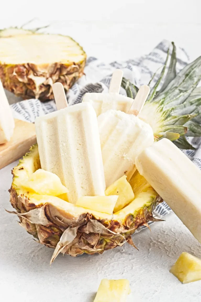 Rumless pina colada popsicles served in a pineapple with pineapple chunks