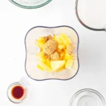 Pineapple and dark brown sugar in a blender for rumless pina colada popsicles