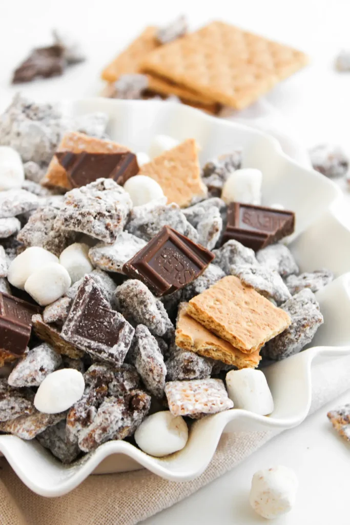 S'mores muddy buddies snack mix with marshmallows, graham crackers, and chocolate