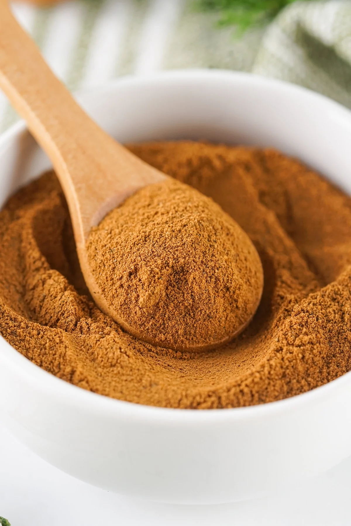 Closeup of homemade allspice substitute on a wooden spoon.