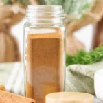 Homemade allspice substitute stored in a clear spice jar.