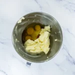 Eggs and vanilla added to creamed butter for churro cookie dough