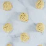 Scoops of churro cookie dough portioned on parchment