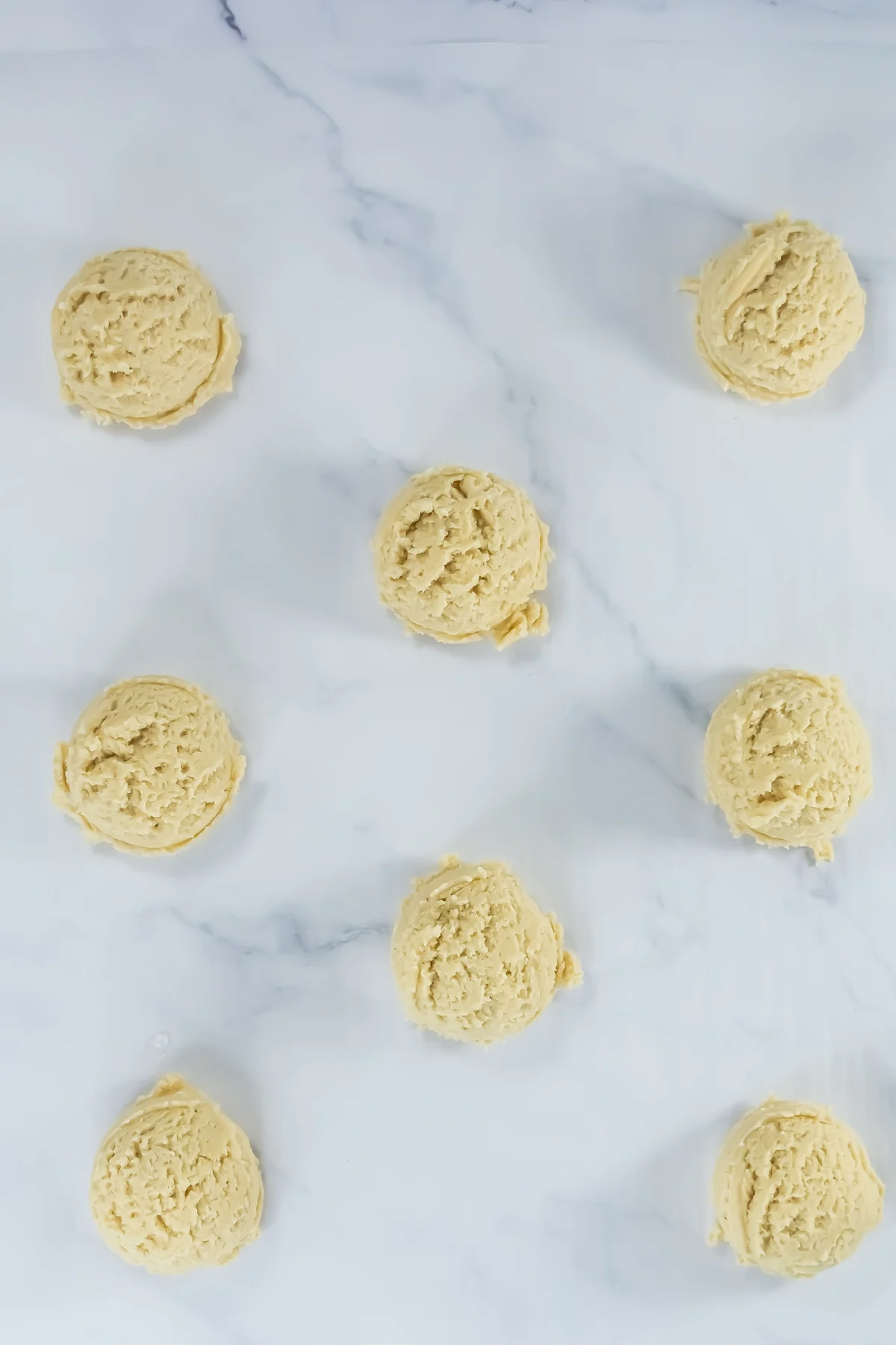 Scoops of churro cookie dough portioned on parchment