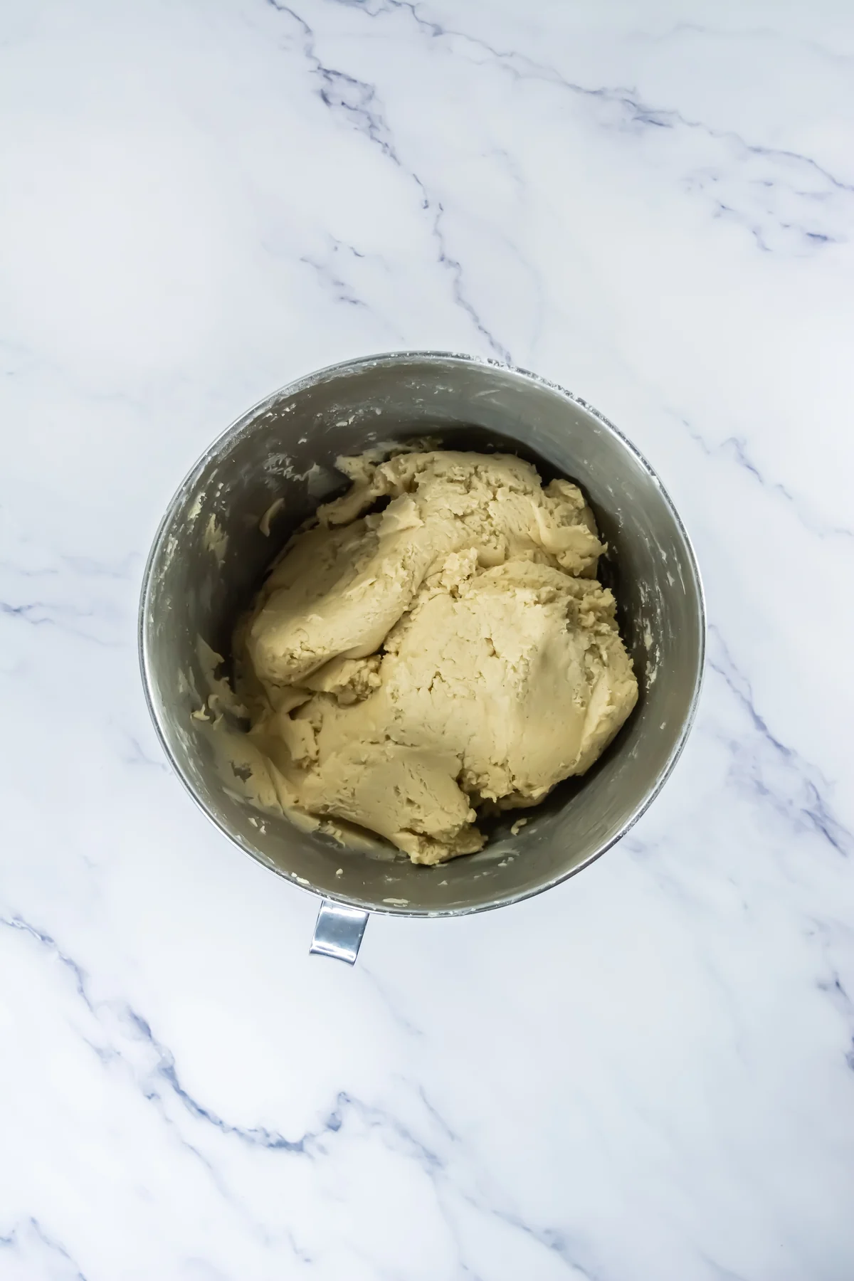 Thick churro cookie dough mixed in a stand mixer bowl