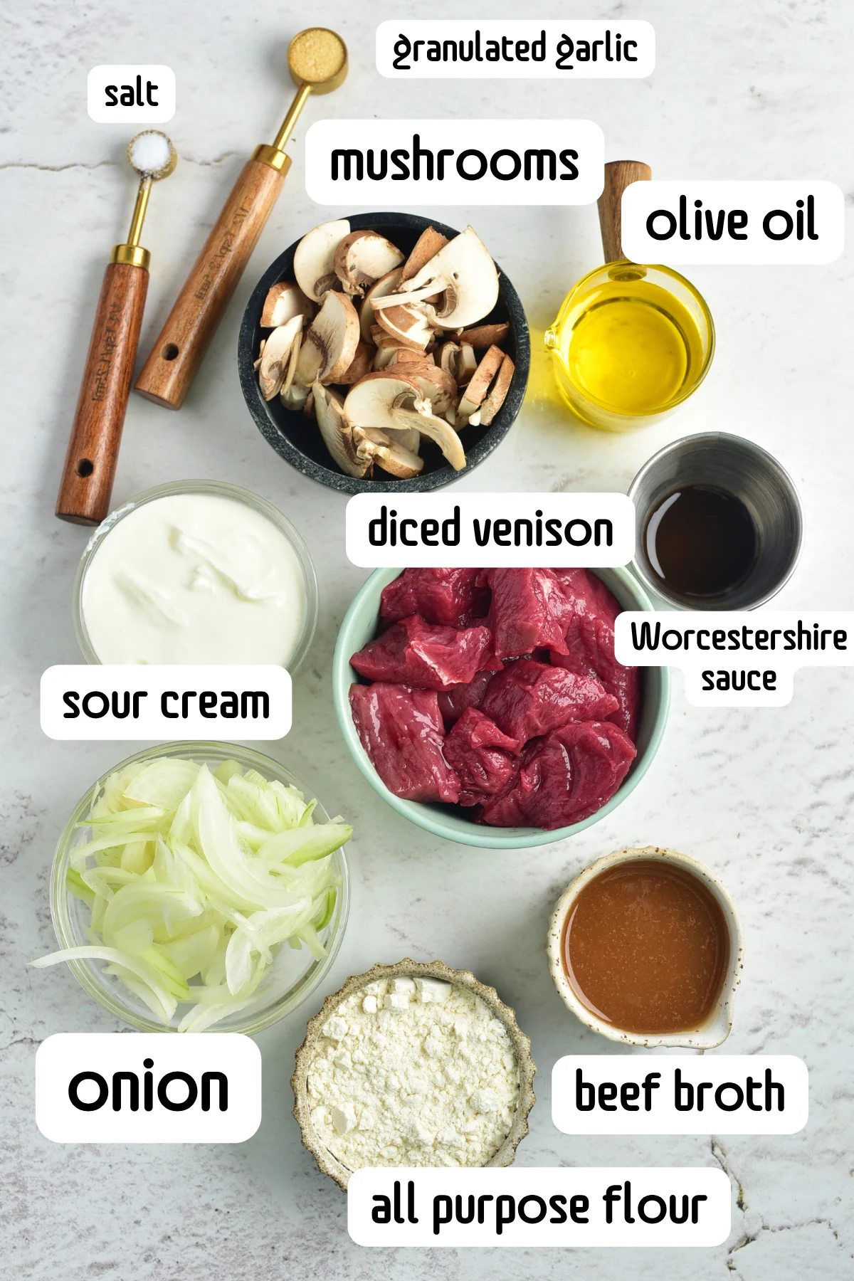 Ingredients for creamy venison stroganoff including venison, mushrooms, onion, sour cream, broth, flour, and Worcestershire sauce