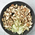 Sliced mushrooms and onions in a skillet