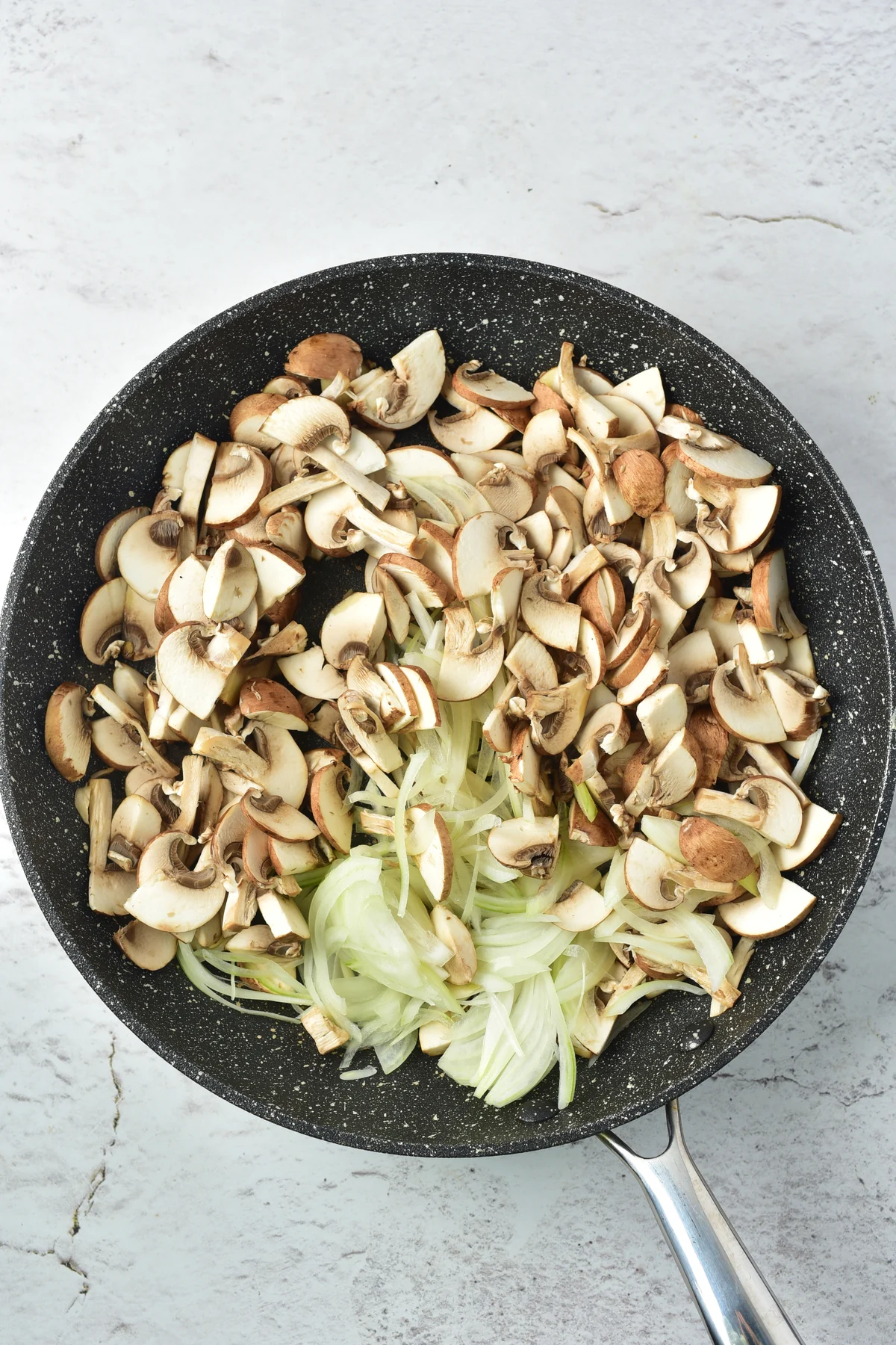 Sliced mushrooms and onions in a skillet