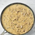 Creamy venison stroganoff sauce simmering in a skillet