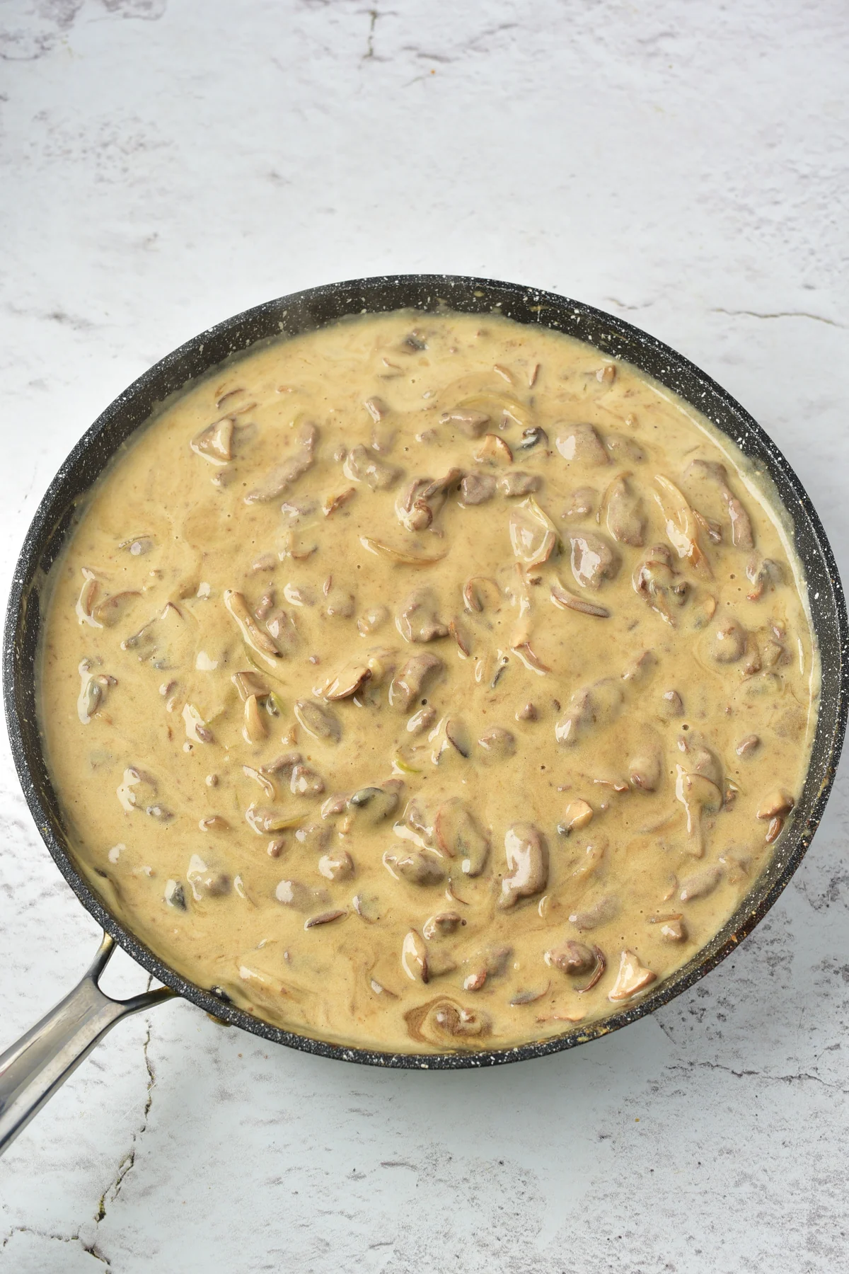Creamy venison stroganoff sauce simmering in a skillet