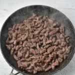 Venison strips browned in a skillet for stroganoff