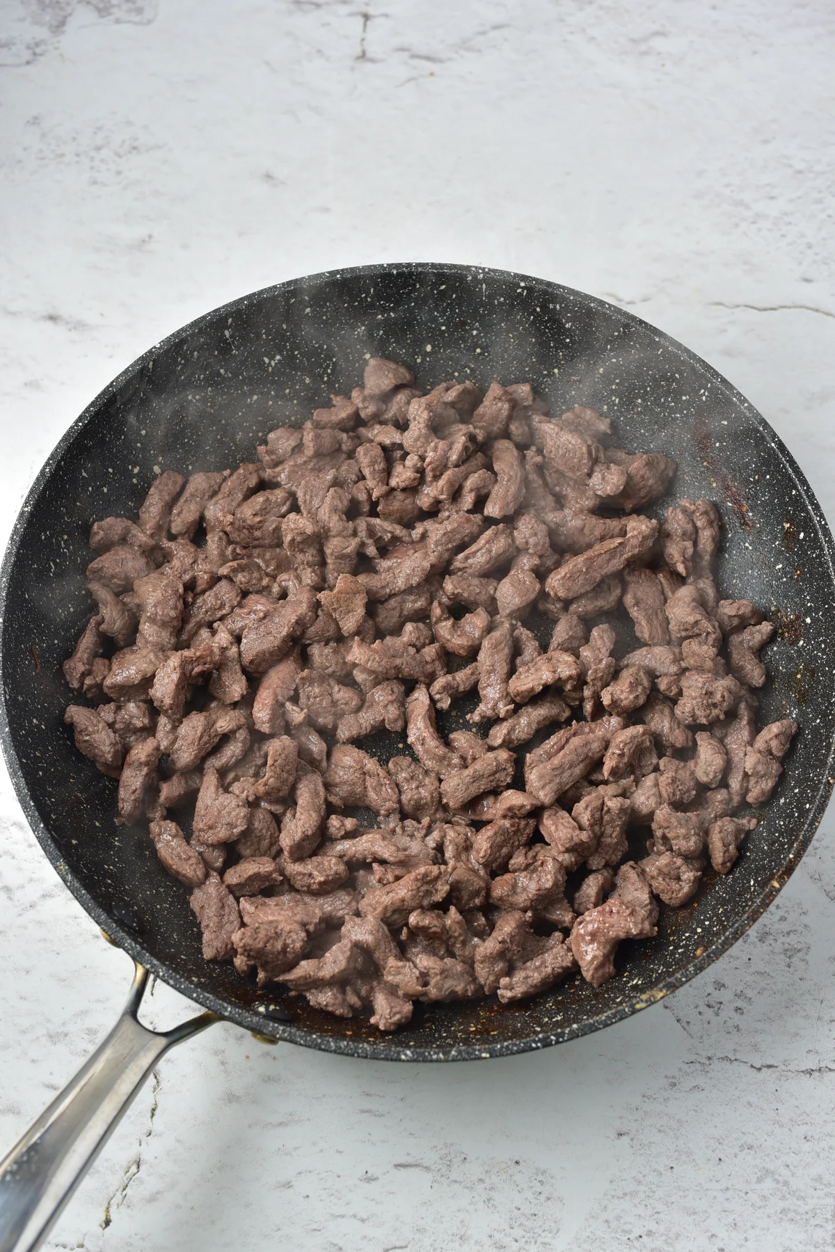 Venison strips browned in a skillet for stroganoff