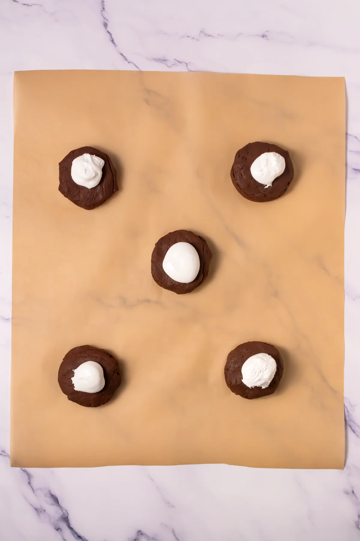 Chocolate cookie dough portions topped with frozen marshmallow fluff.