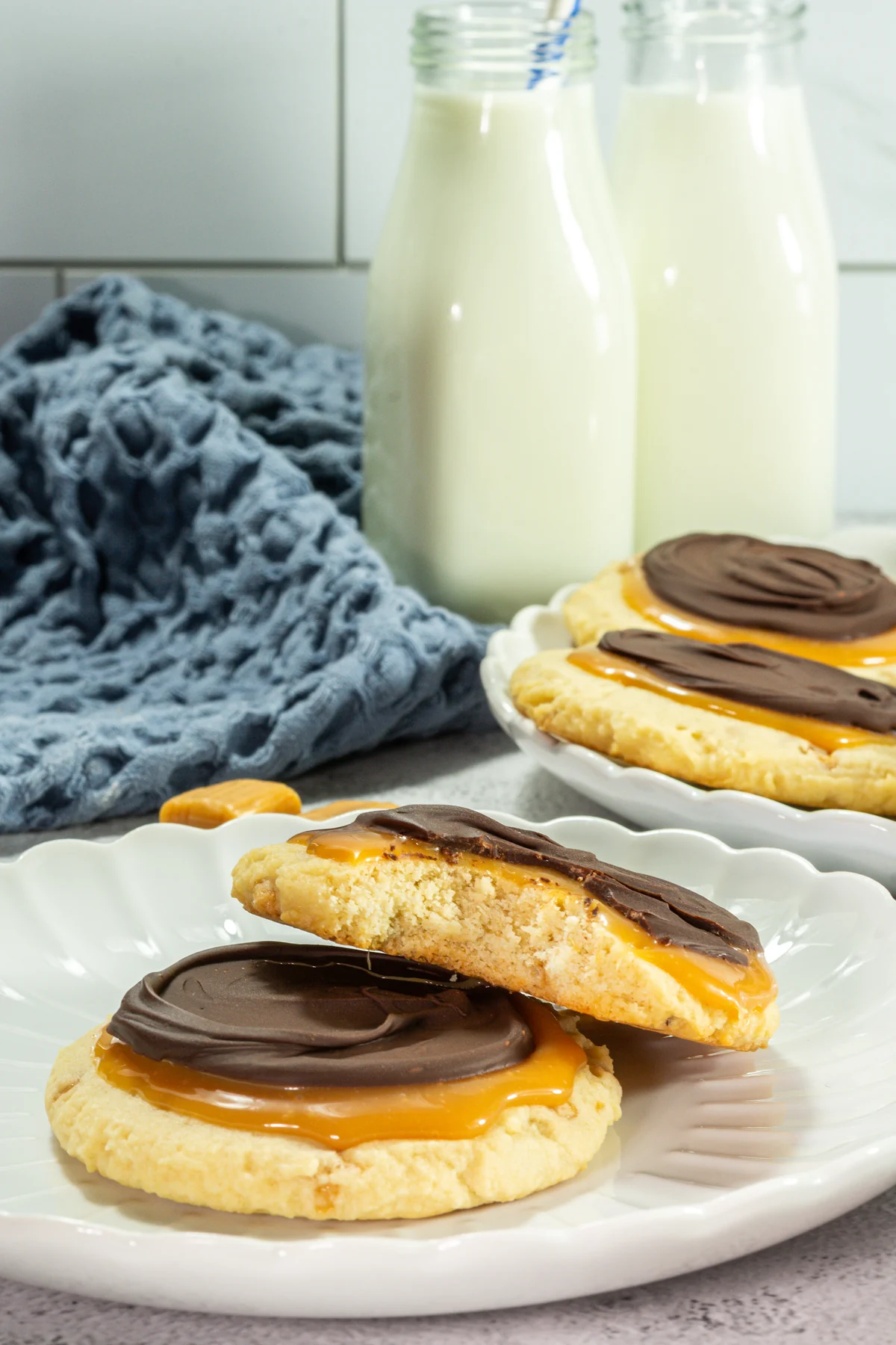 Crumbl Copycat Twix Cookies With Caramel and Toffee Chocolate caramel cookie broken open to show its soft center and toffee pieces.