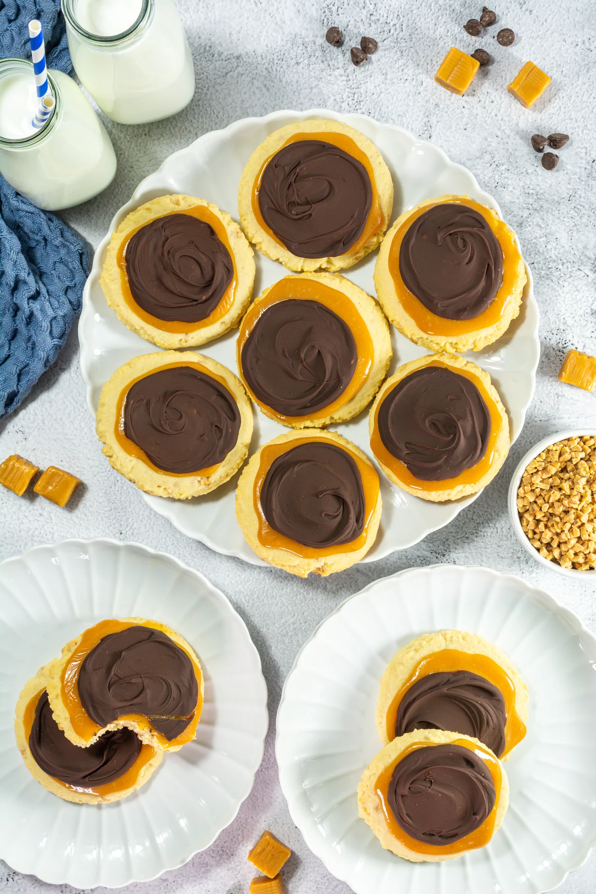 Crumbl Copycat Twix Cookies With Caramel and Toffee Soft copycat Twix Crumbl cookies with caramel and melted chocolate on a serving plate.