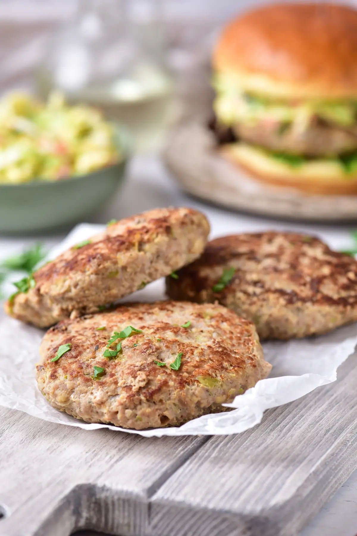 Cooked ground chicken burger patties on parchment
