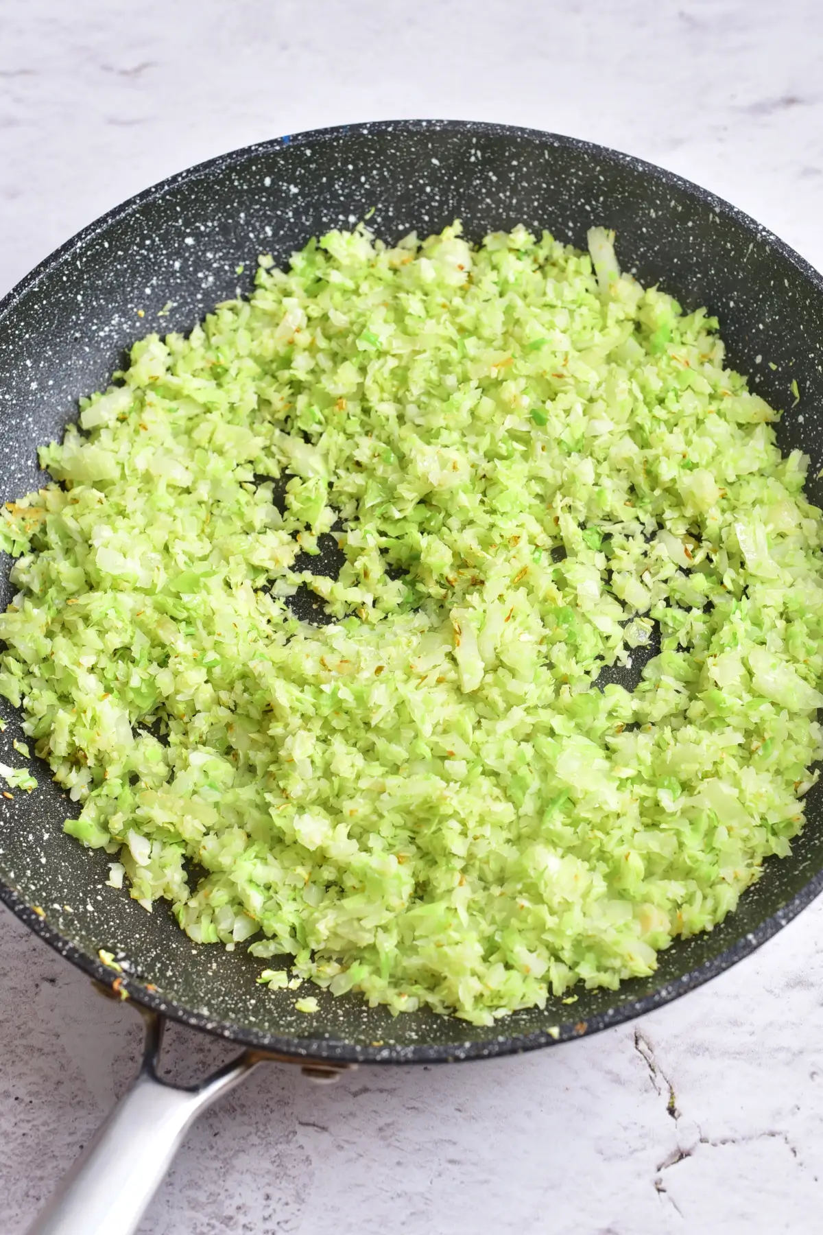 Chopped cabbage and onion softened in a skillet