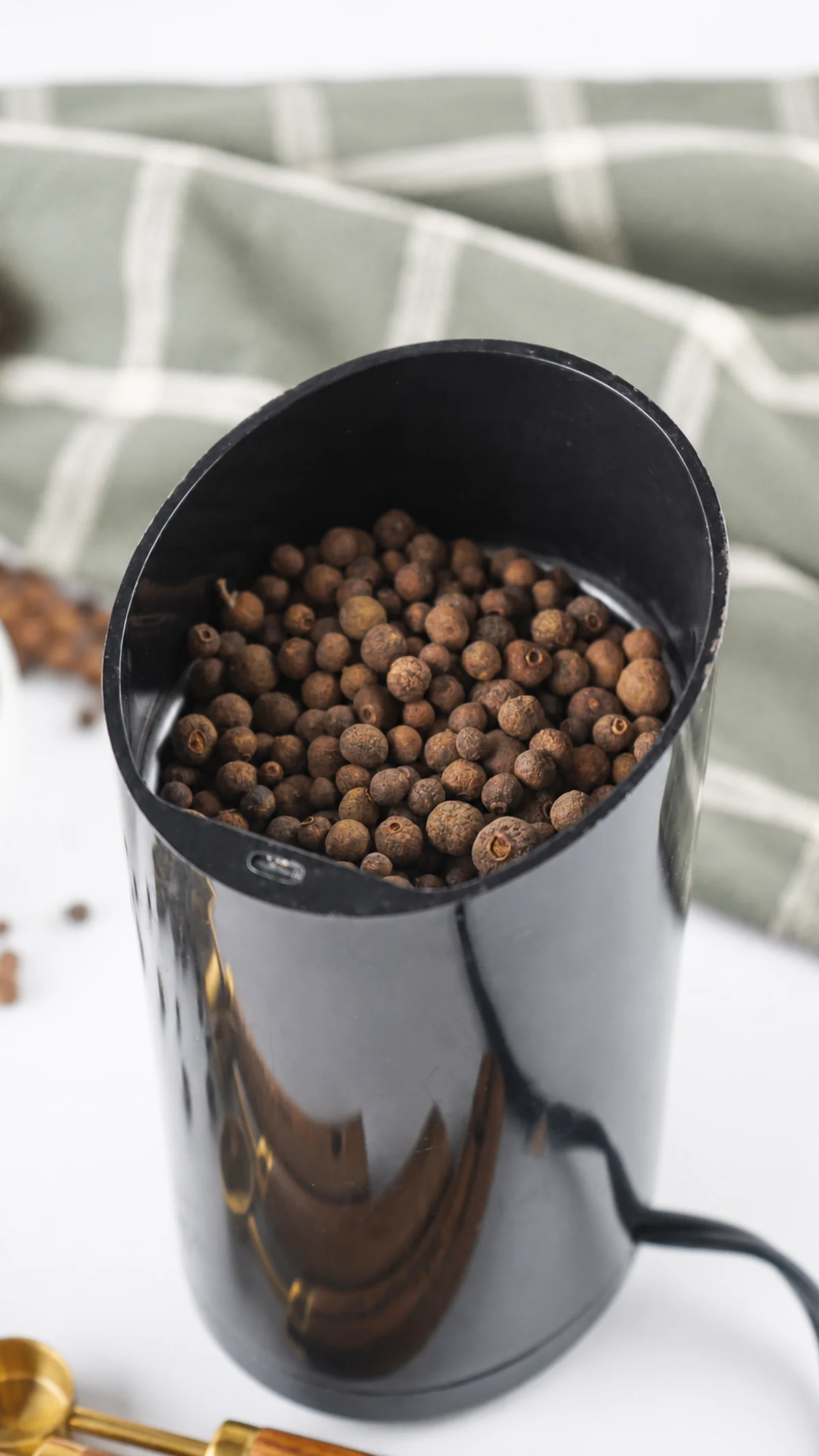 How to Make Ground Allspice From Whole Berries Whole allspice berries in an electric spice grinder.