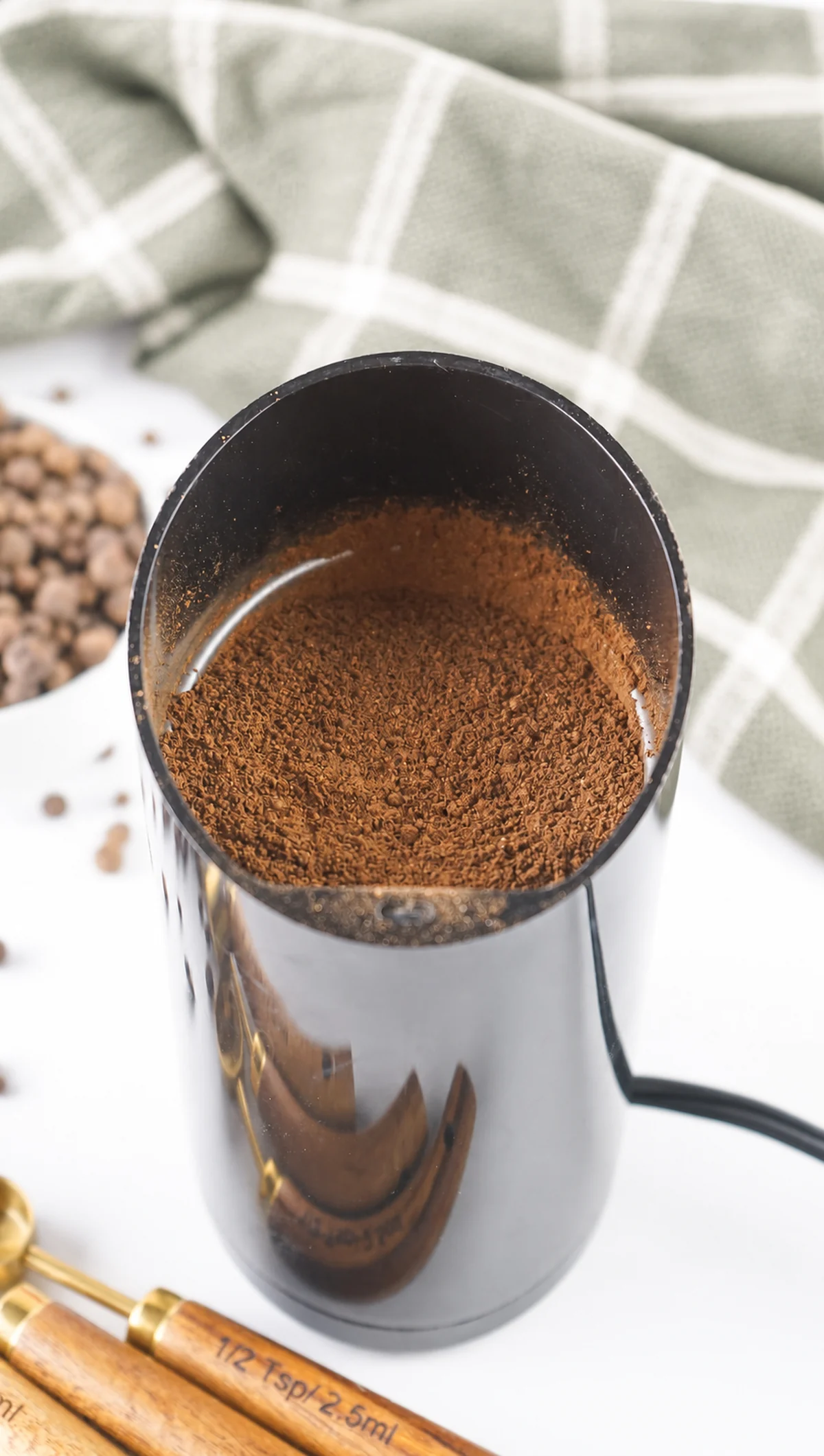 How to Make Ground Allspice From Whole Berries Fresh ground allspice powder inside a spice grinder.