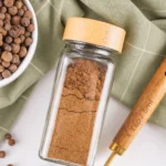 How to Make Ground Allspice From Whole Berries Freshly ground allspice stored in a glass spice jar.