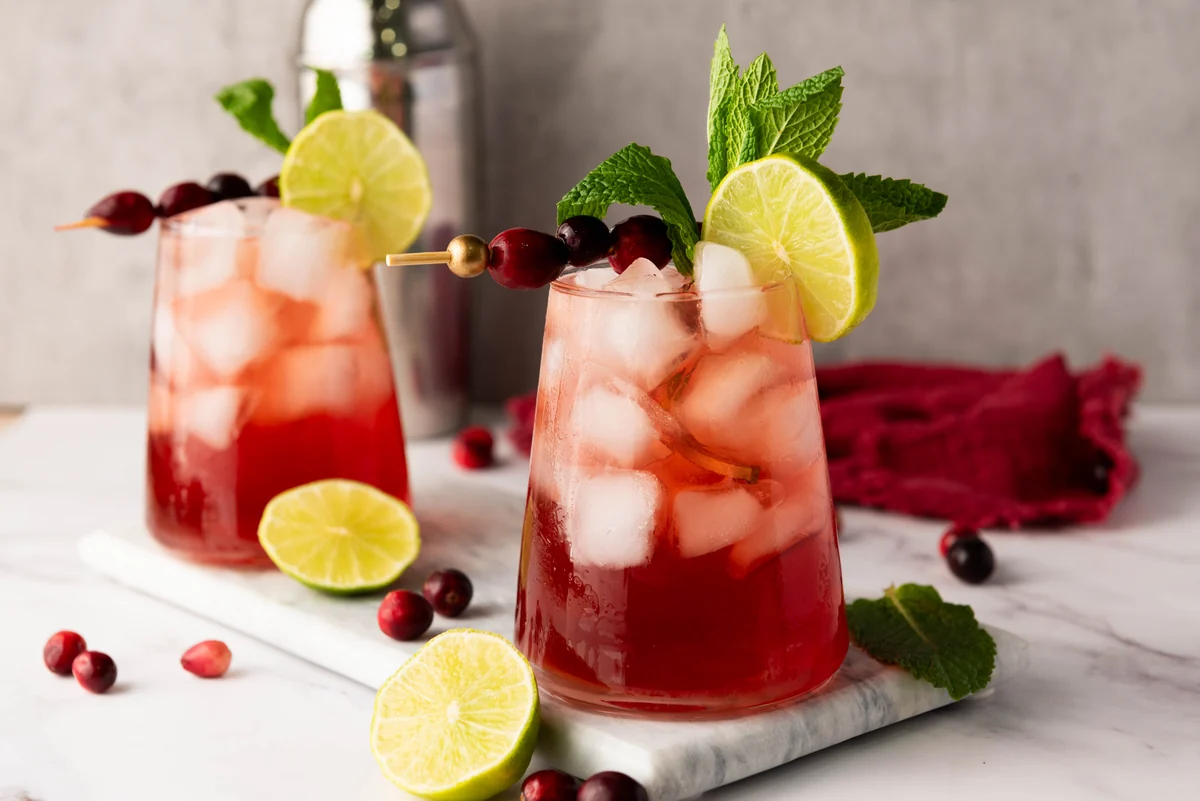 Cranberry lime mocktails garnished with fresh cranberries, lime slices, and mint.