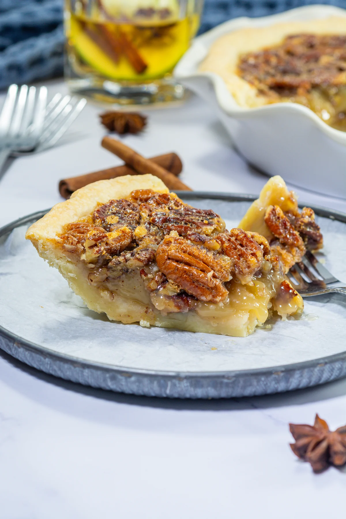 Close-up slice of bourbon pecan pie with gooey filling, pecans, and flaky crust.