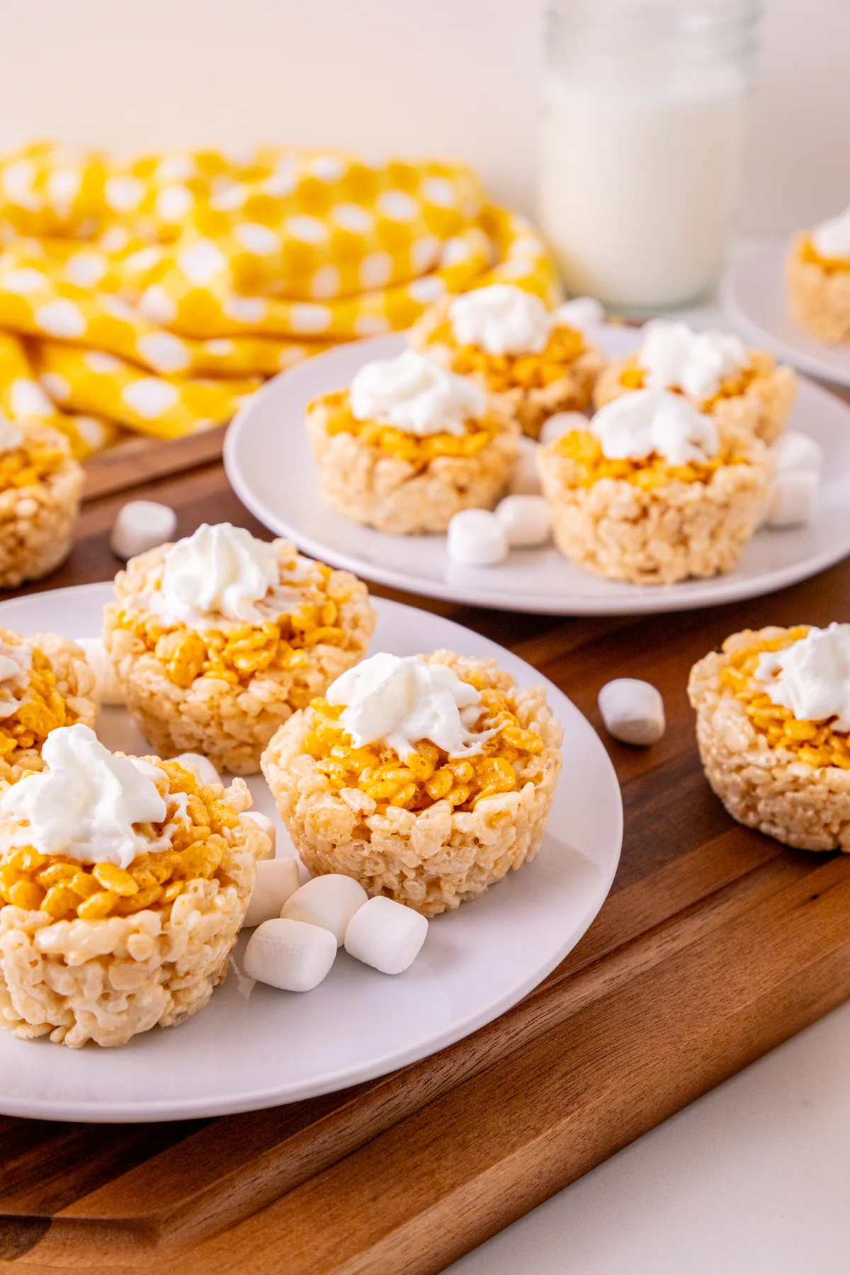 Close-up of individual pumpkin pie Rice Krispie treats with marshmallows nearby.