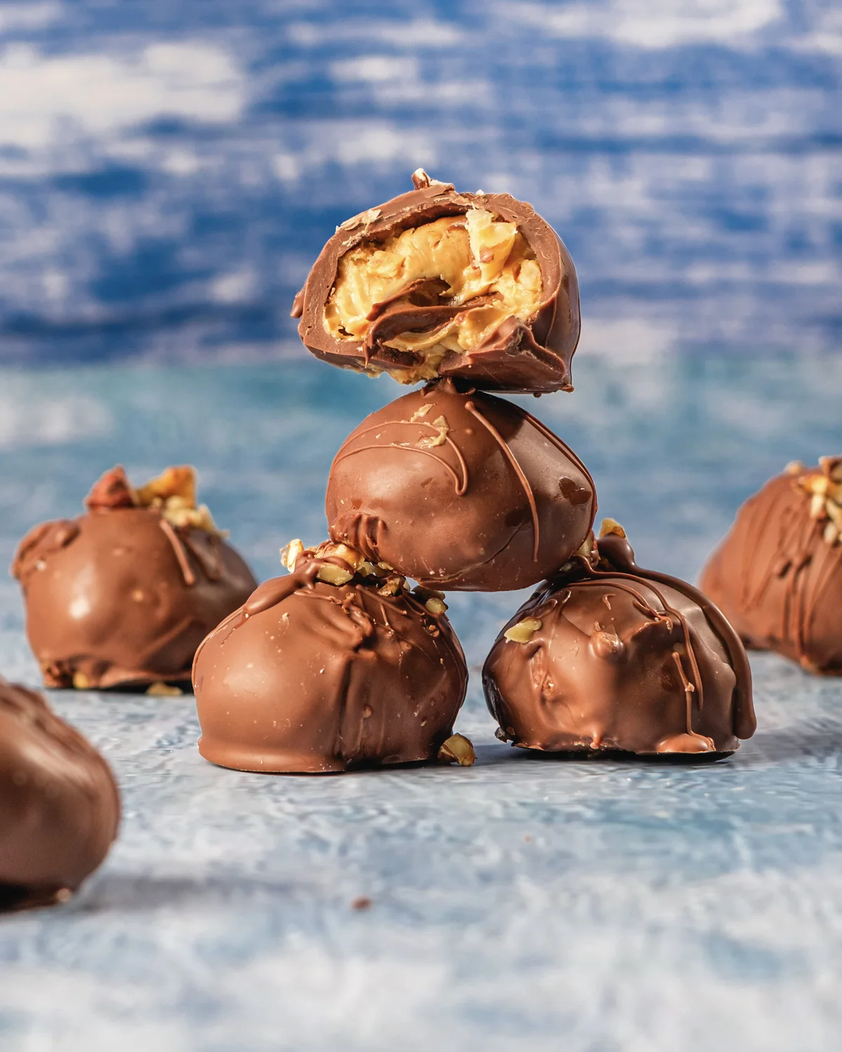 Chocolate covered peanut butter balls with one cut open to show the Nutella center.