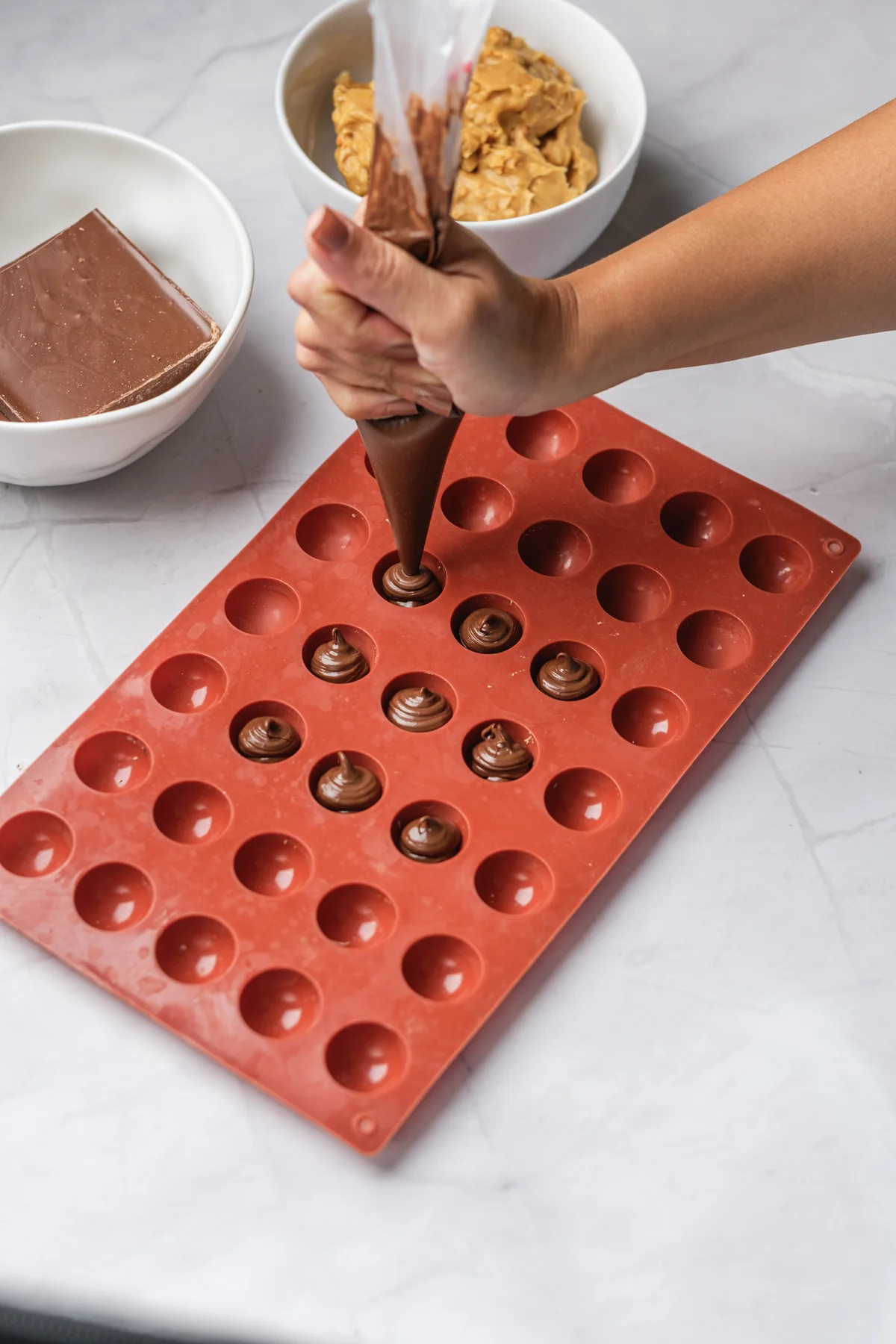 Nutella piped into small portions in a silicone mold before freezing.