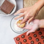 Peanut butter mixture flattened by hand before wrapping around frozen Nutella.