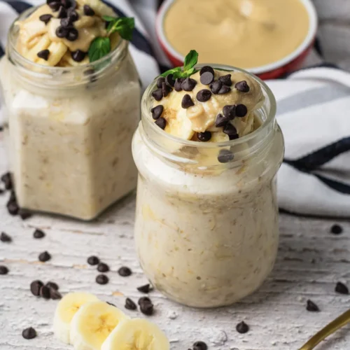 Peanut Butter Banana Overnight Oats Without Yogurt Creamy peanut butter banana overnight oats in jars with banana slices, chocolate chips, and peanut butter.