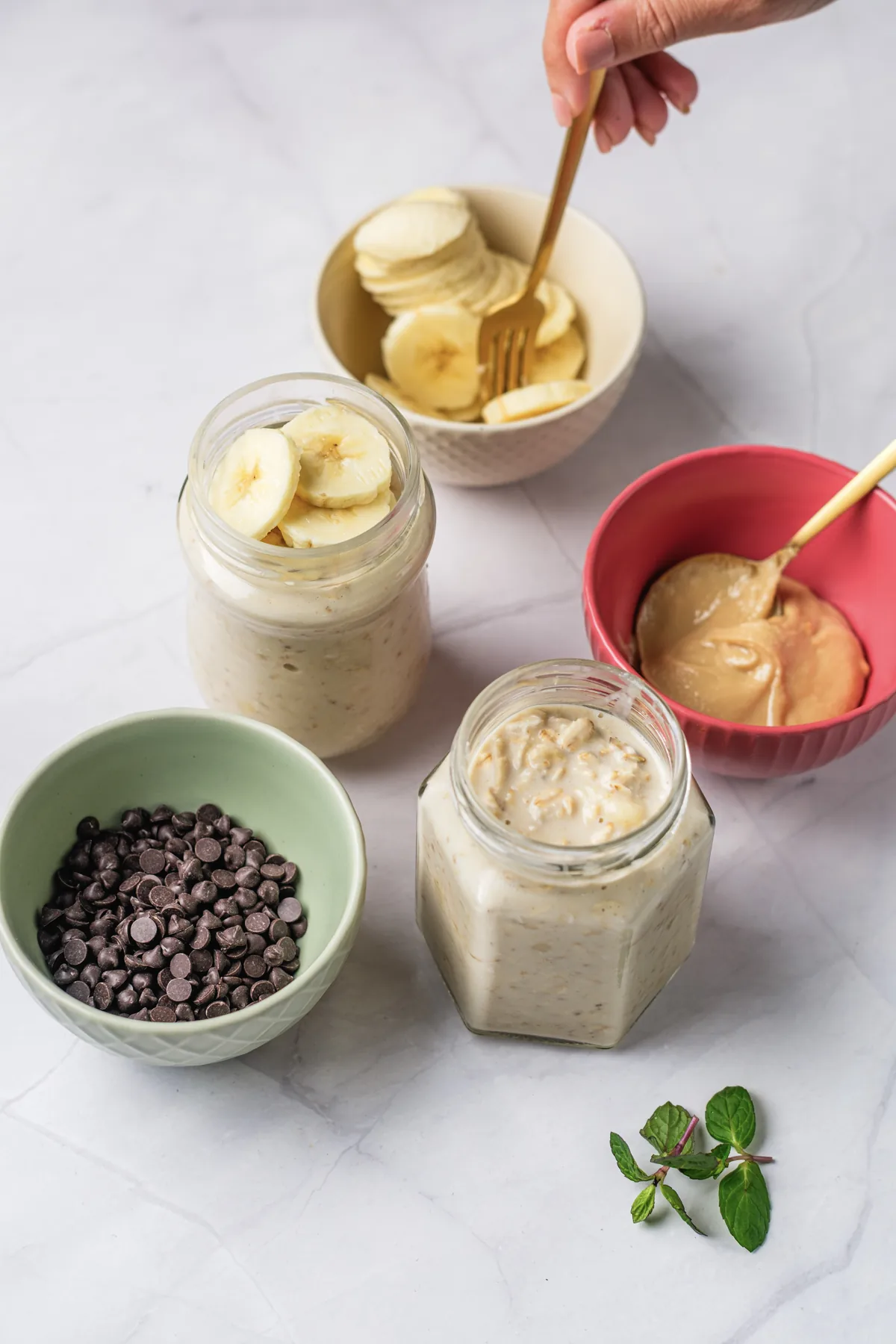 Peanut Butter Banana Overnight Oats Without Yogurt Banana slices, peanut butter, and chocolate chips added to jars of overnight oats.