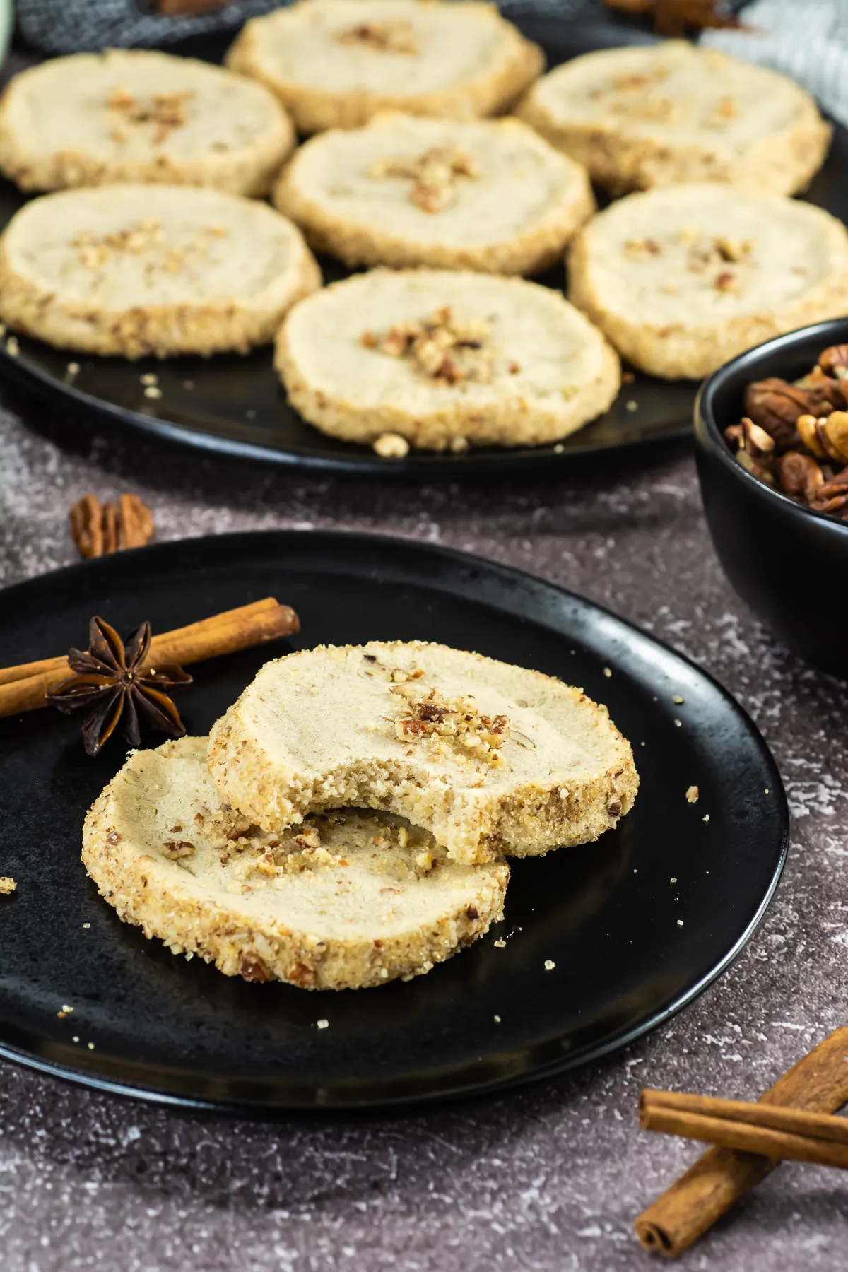 Broken pecan shortbread cookie showing the crisp crumb and pecan pieces.