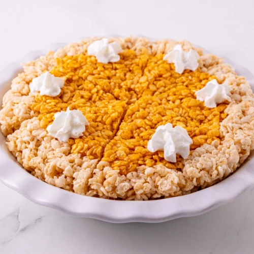 Pumpkin Pie Rice Krispie Treats in a pie plate with whipped topping.