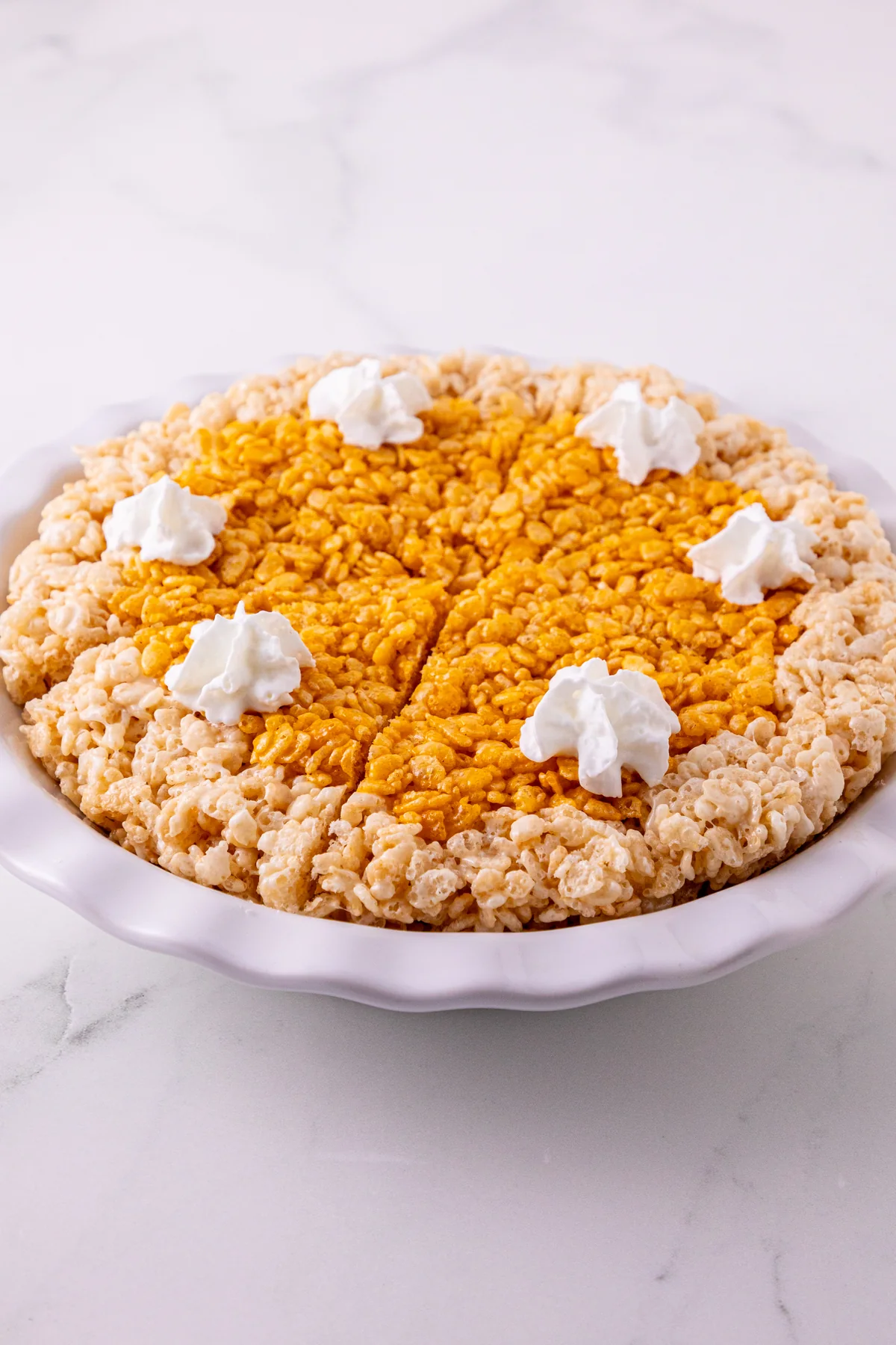 Pumpkin Pie Rice Krispie Treats – The No-Bake Pie You Can Slice Pumpkin Pie Rice Krispie Treats in a pie plate with whipped topping.