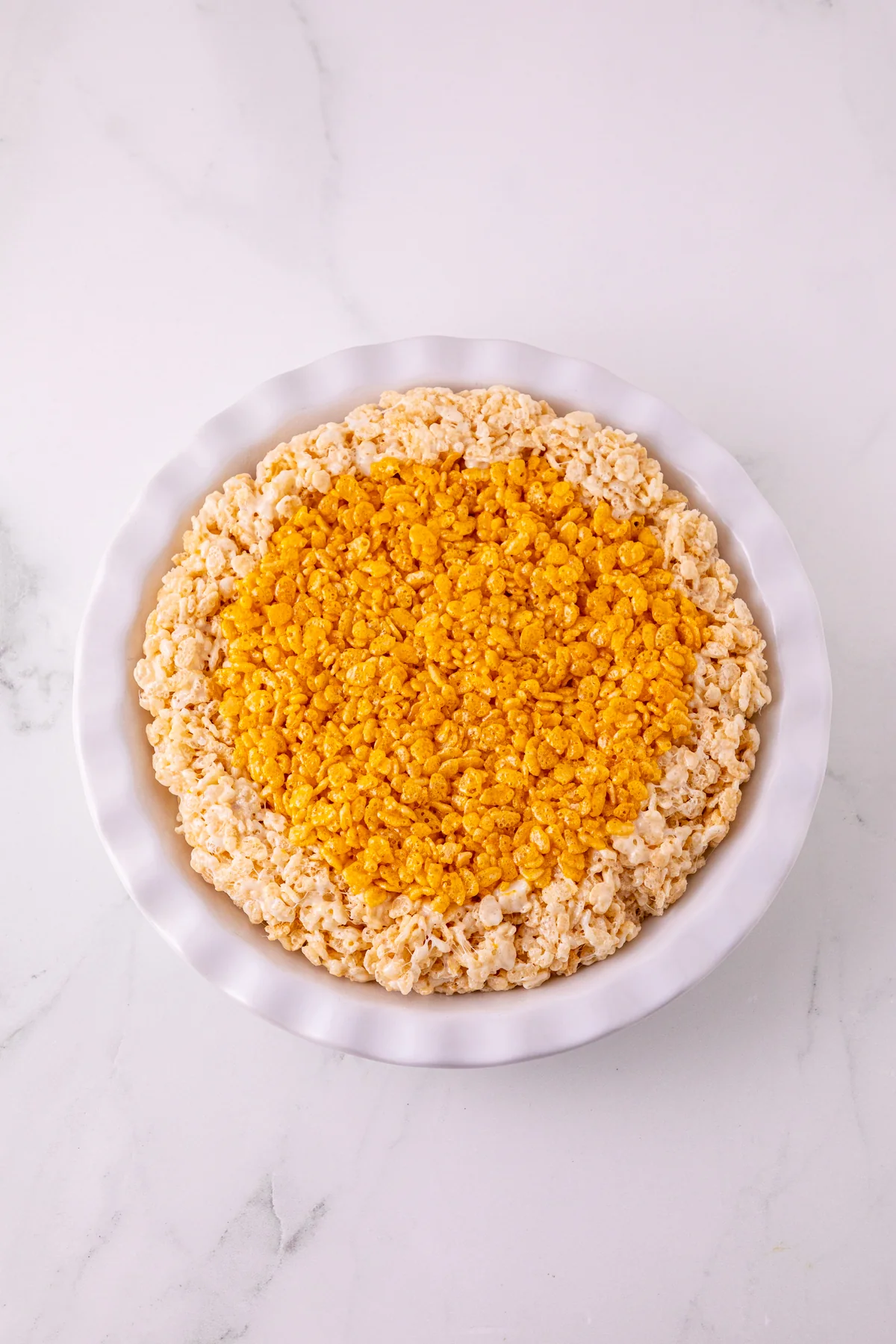 Pumpkin Rice Krispie filling pressed into the cereal crust before slicing.
