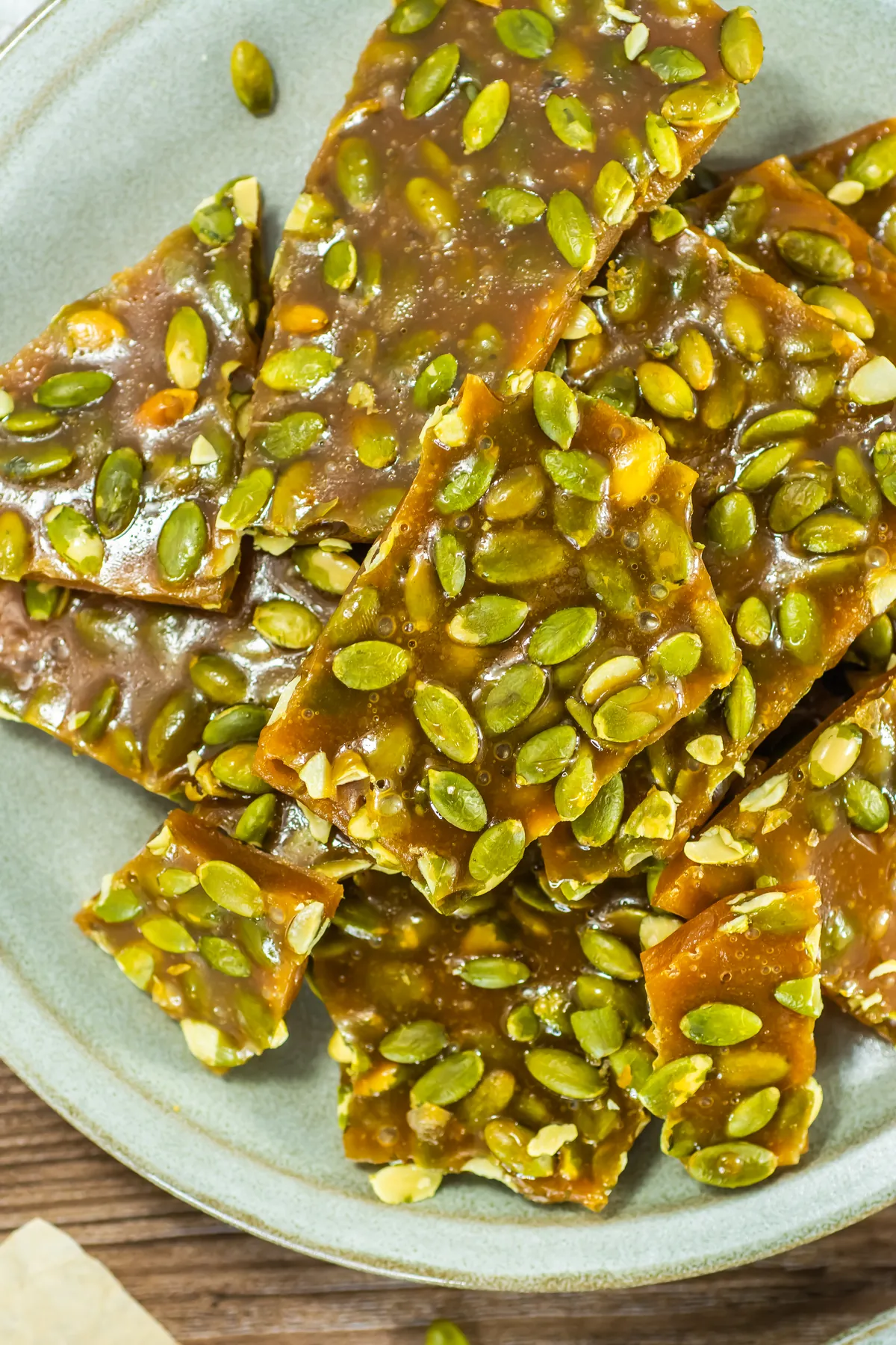 Easy Pumpkin Seed Brittle With Honey (No Corn Syrup) Close-up of pumpkin seed brittle pieces with glossy honey caramel and toasted pepitas.
