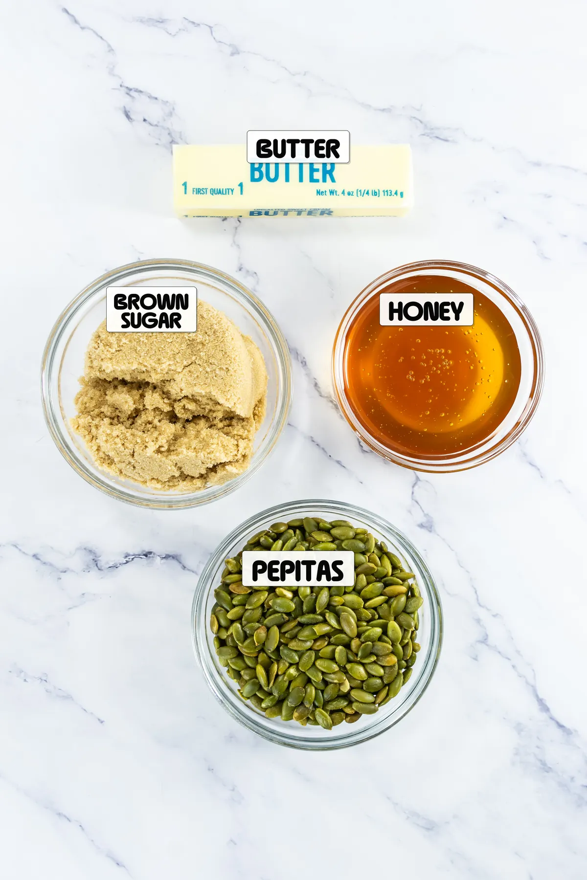 Butter, brown sugar, honey, and pepitas labeled for pumpkin seed brittle.