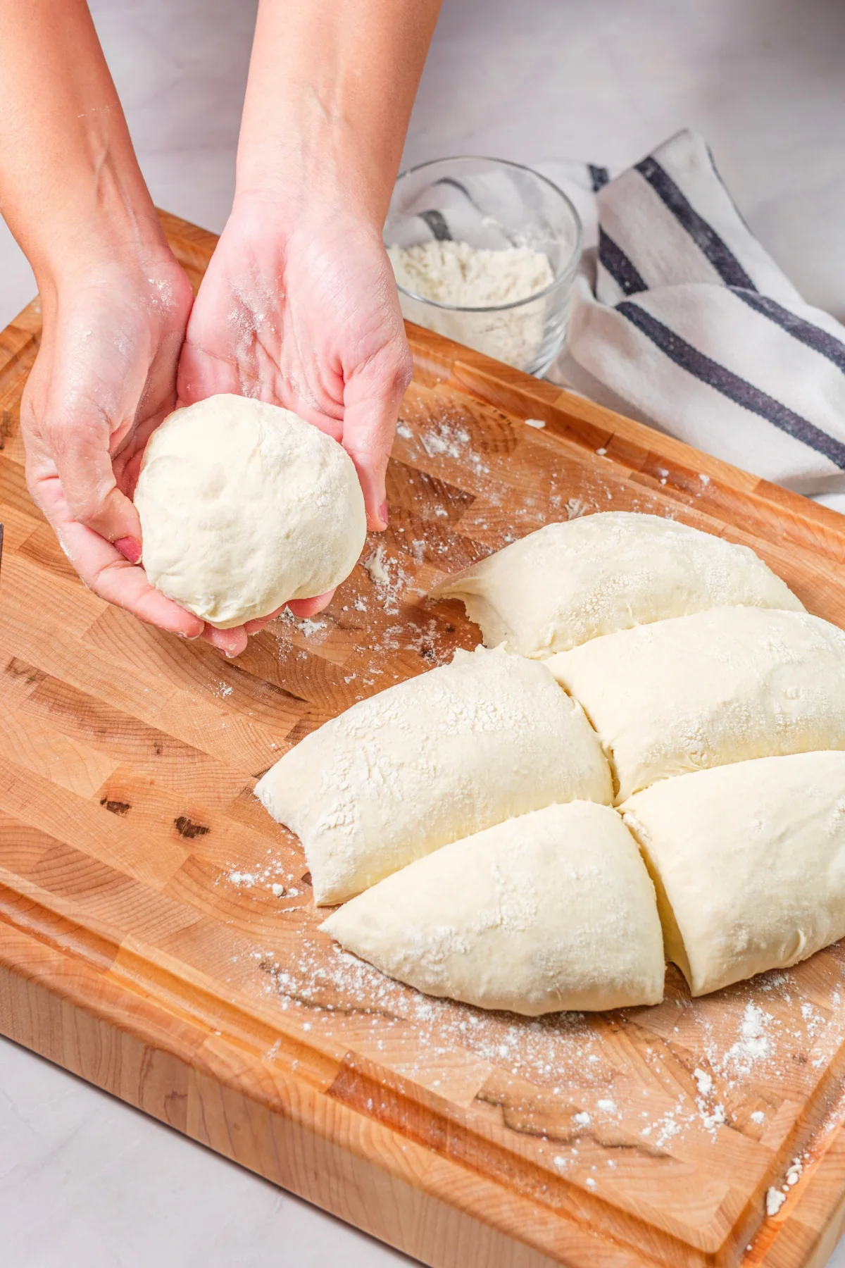 Risen pretzel dough divided into portions on a floured board.
