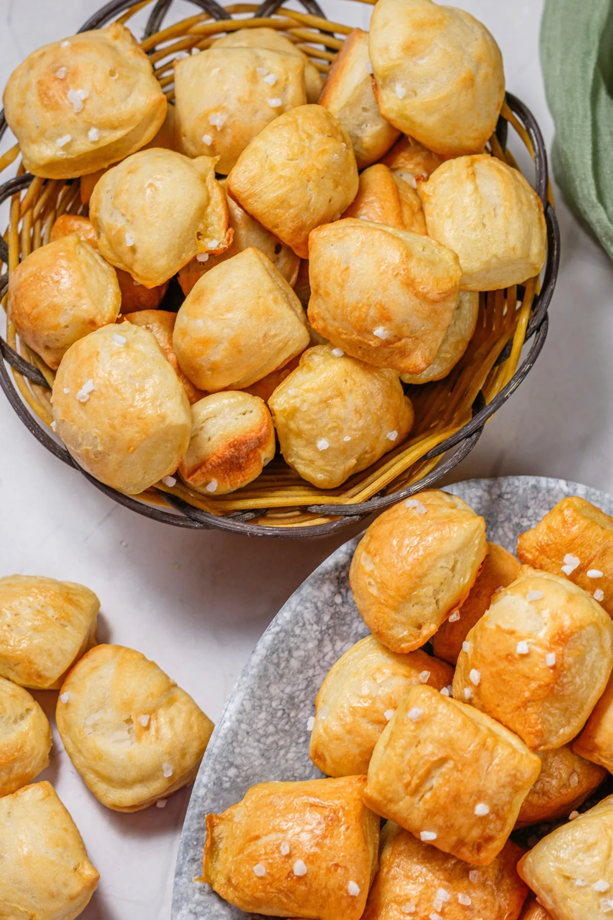 Homemade pretzel bites in a basket and on a plate with coarse salt.