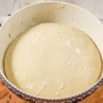 Pretzel dough risen until puffy in a large bowl.