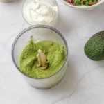 Smooth blended avocado in a food processor bowl