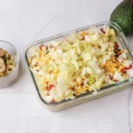 Shredded lettuce layer on top of the dip in a glass dish