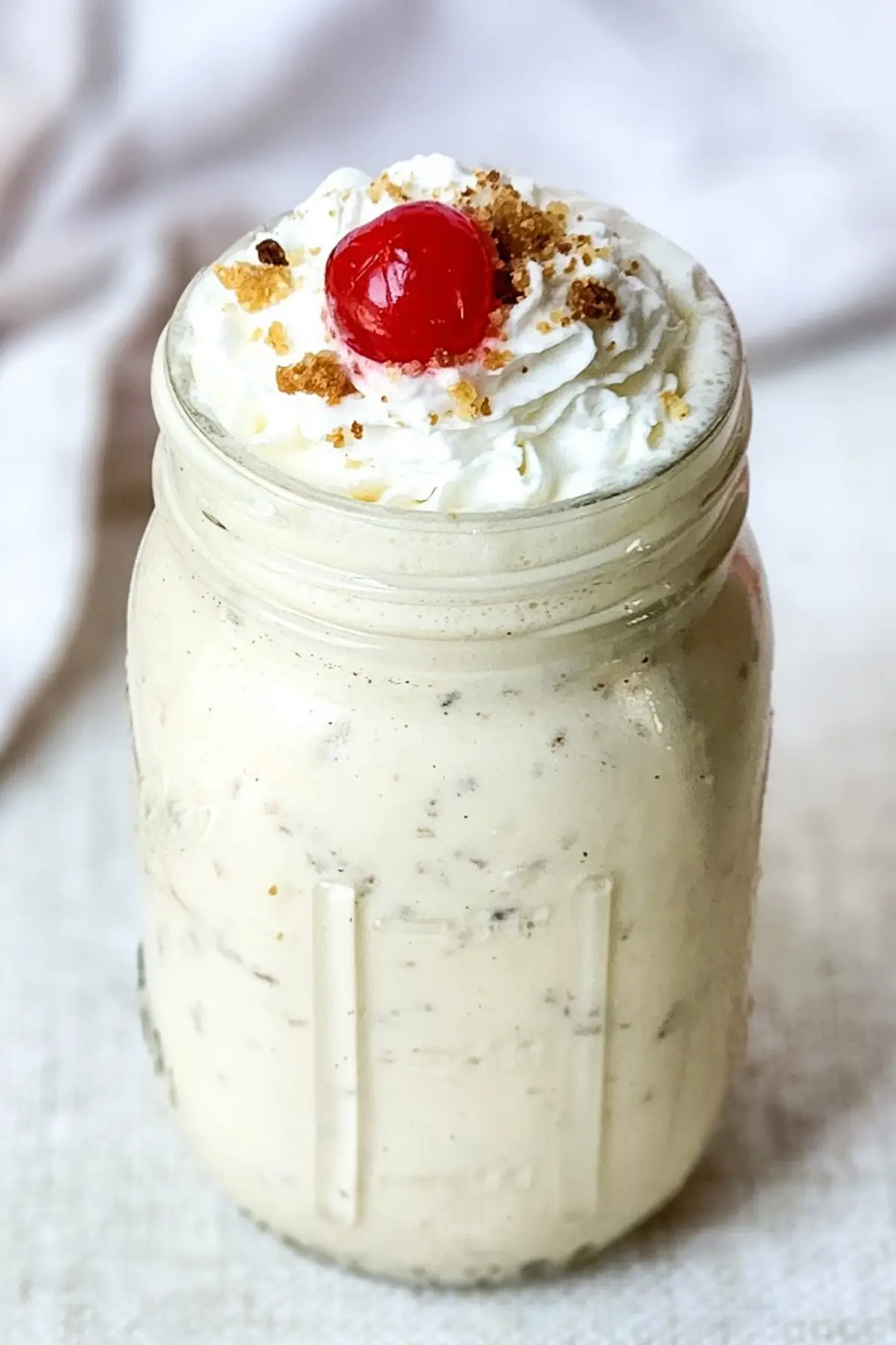Caramel crumble milkshake topped with whipped cream and cherry