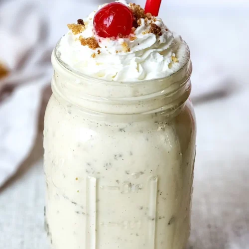 Caramel crumble milkshake topped with whipped cream and cherry