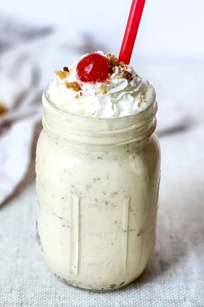 Caramel crumble milkshake topped with whipped cream and cherry