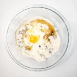 Muffin ingredients combined in a glass bowl before they are mixed together.
